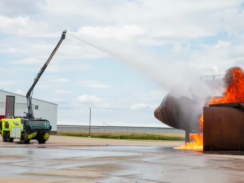 An image of an Oshkosh fire ARFF vehicle extinguishing a blaze