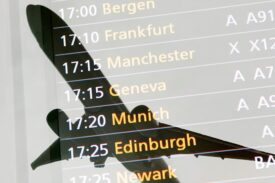 An image of a plane in flight overlaid with departure times