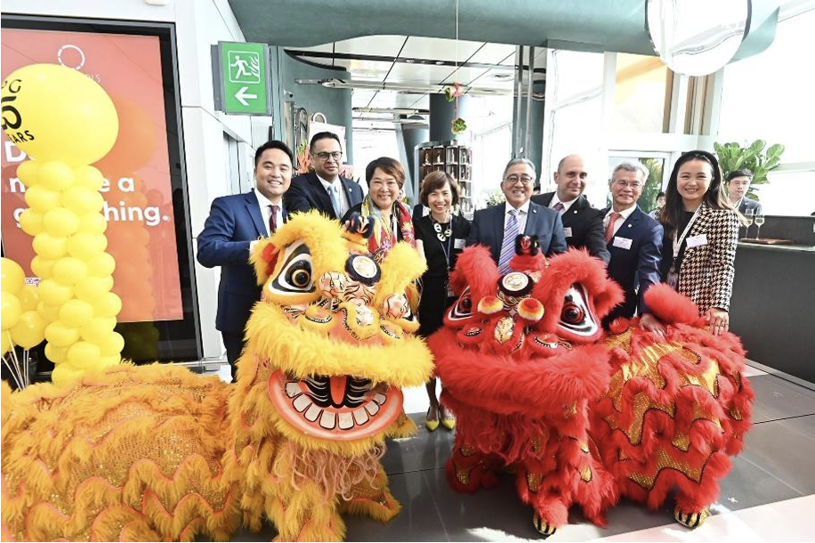 An image of several members of PPG staff with two Chinese dragons to signify the opening of an area at Hong Kong International Airport