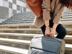 A person struggles to carry baggage up a long flight of steps