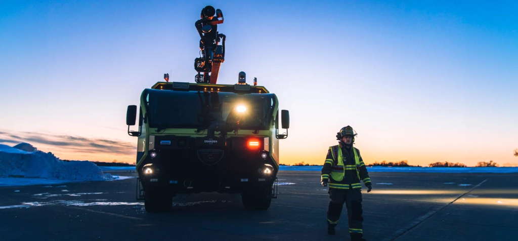 An ARFF vehicle and a fightfighter at sunrise