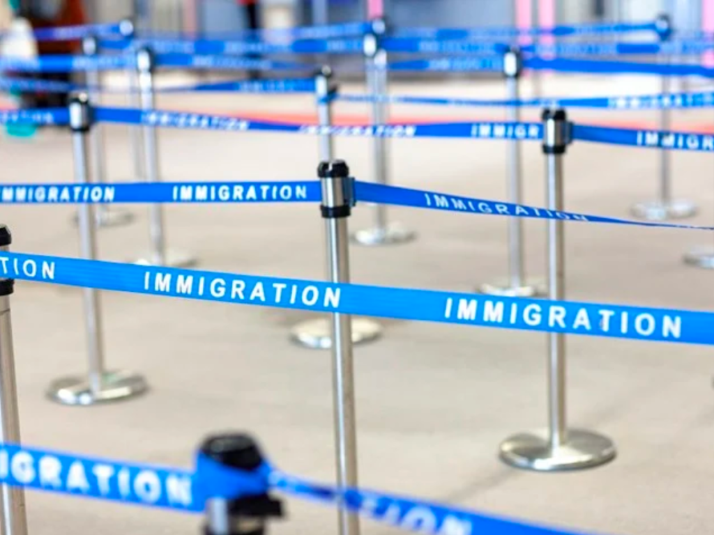 Blue queue barriers which read "Immigration"