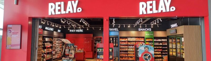 Red wall with 2 doorways to airport duty-free shops