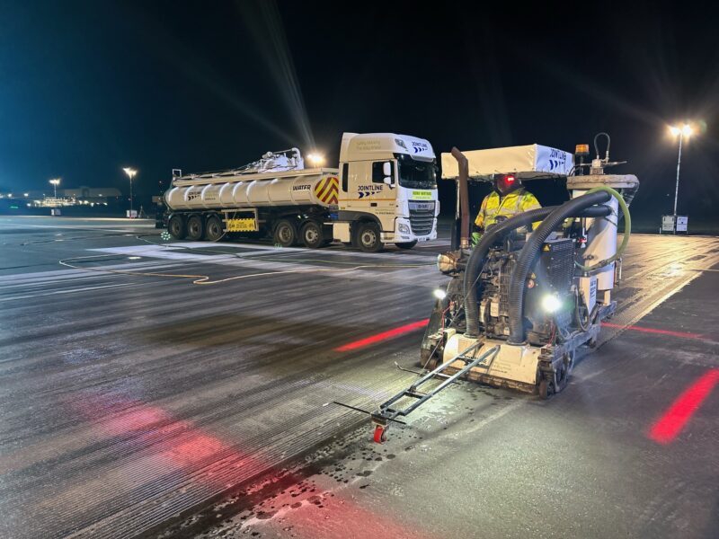 Airport vehicles grooving the runway, night time