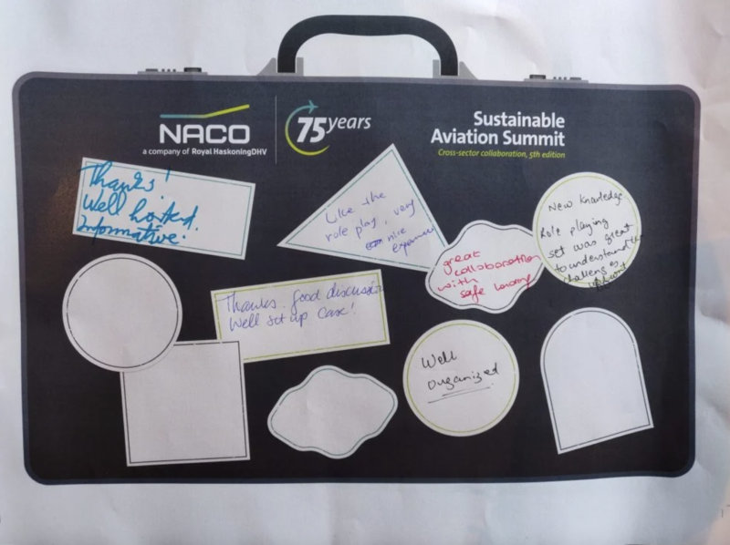 NACO briefcase with multiple white stickers, showing handwritten compliments from visitors