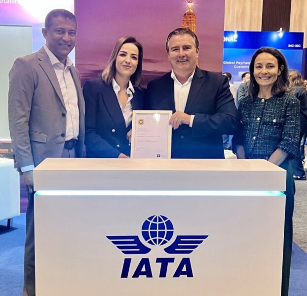 4 people (2 men and 2 women) standing behind a white booth with the blue IATA logo