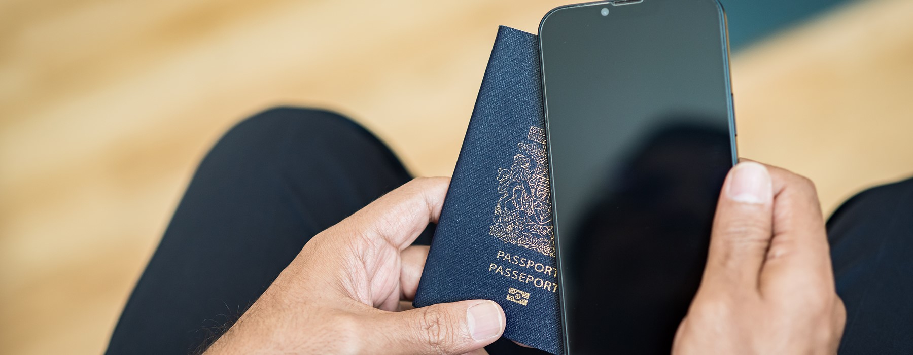 individual holding phone and passport in his hand