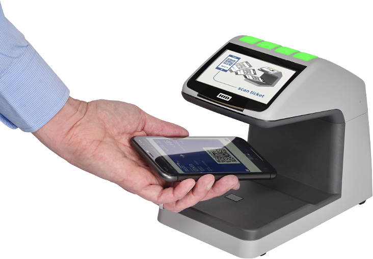 A hand scanning a boarding pass QR code on a phone screen, held under a scanner