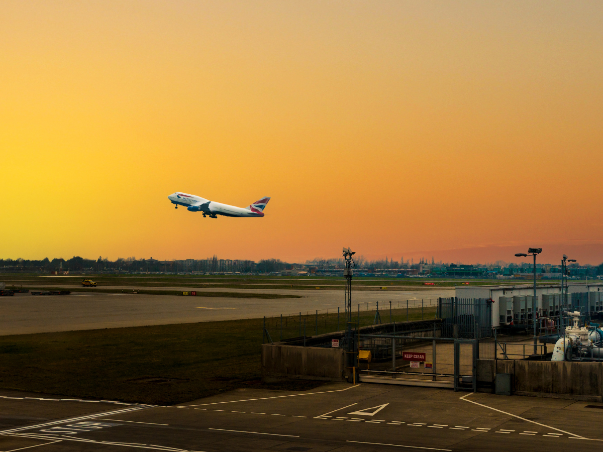 A plane taking off against a sunset