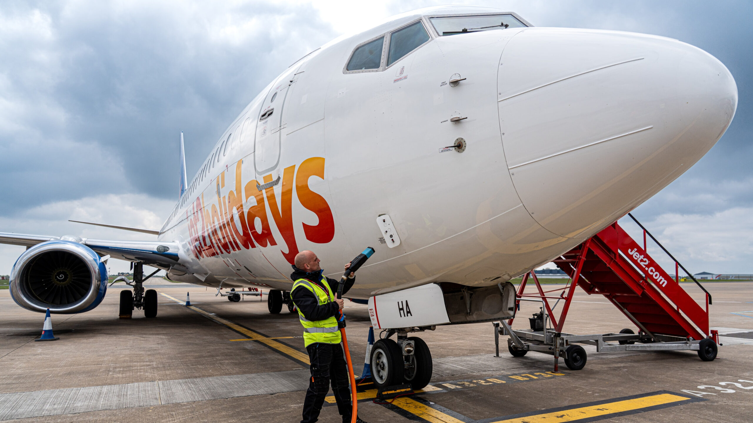 A ground support worker fuelling an airplane
