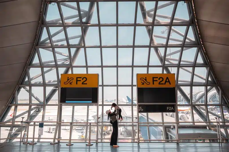 A woman throwing up a child into the air in an airport