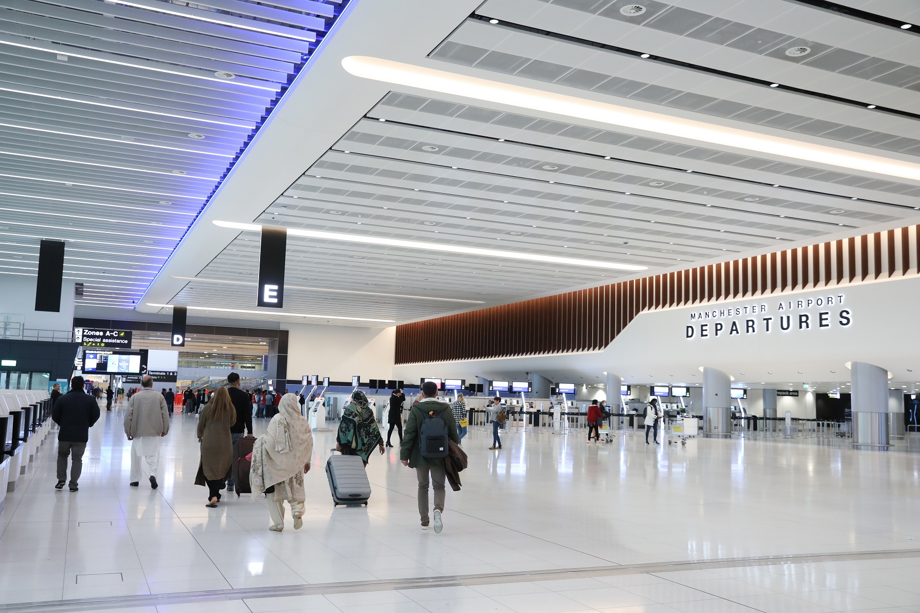 Passengers walking toward check-in at Manchester Airport