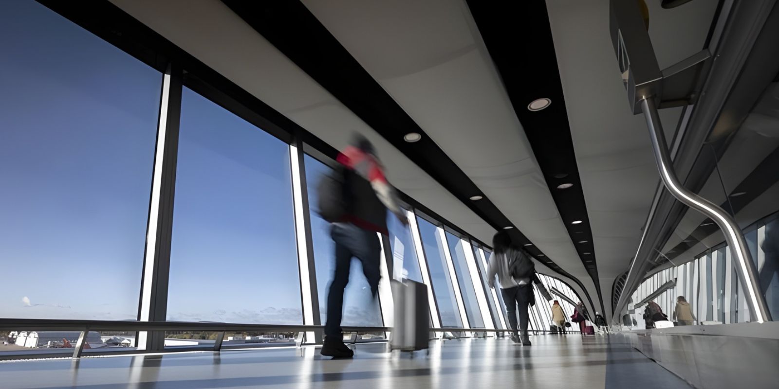 People walking through an airport with luggage