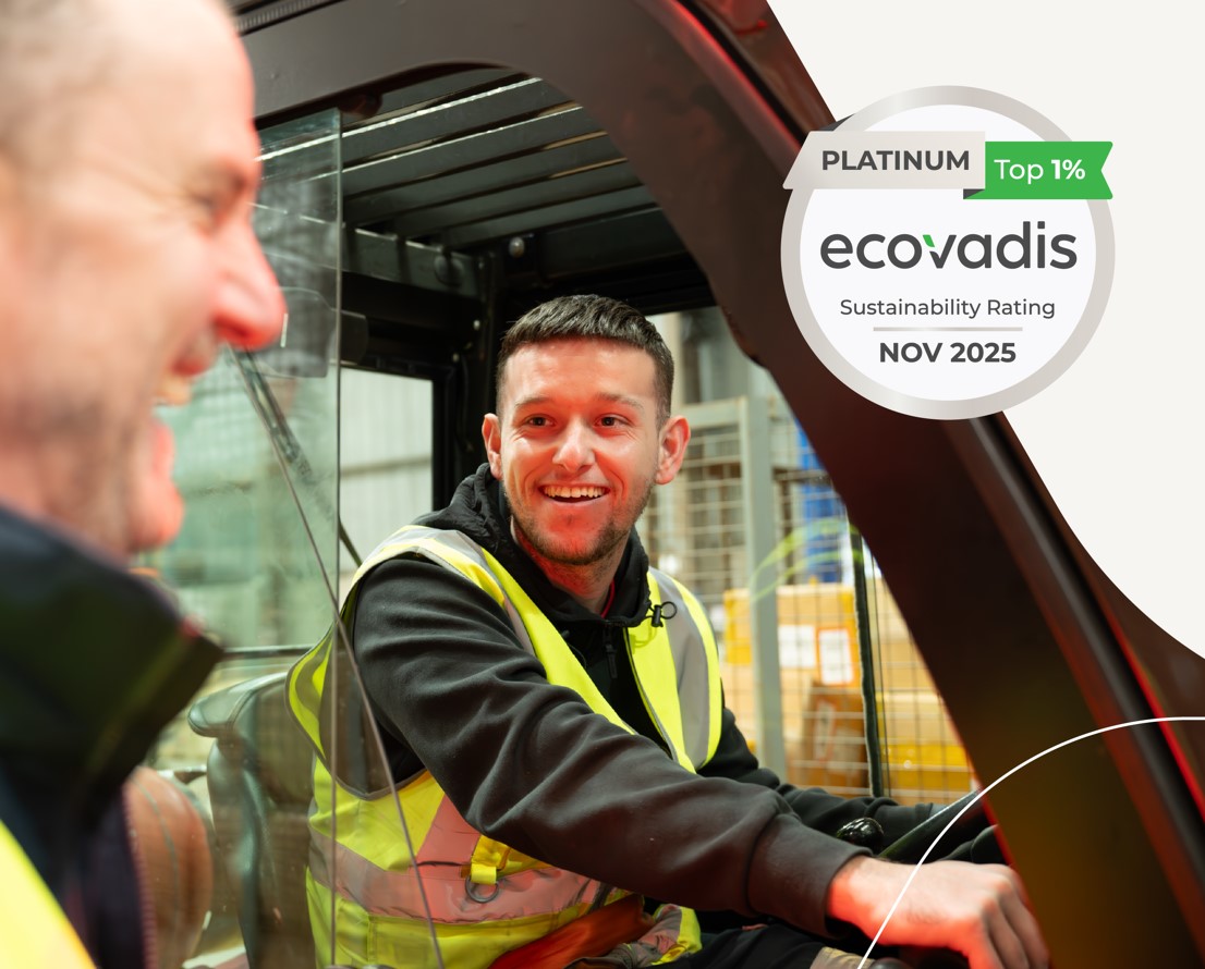 Two people smiling, one in a van