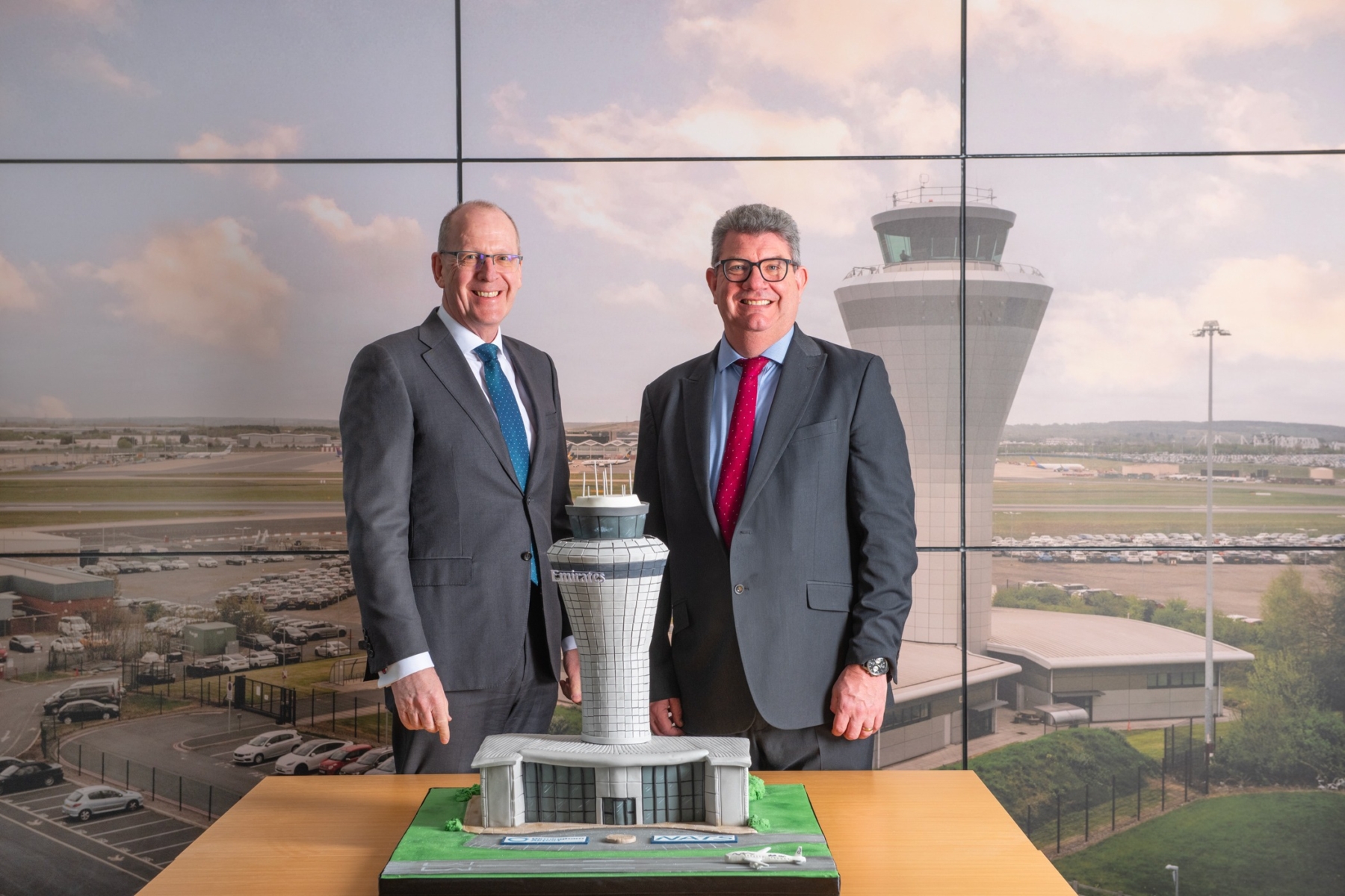 Two men stood by a model of Birmingham Airport