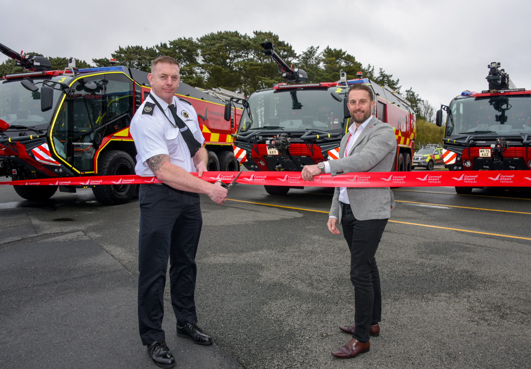 Two people cutting a ribbon