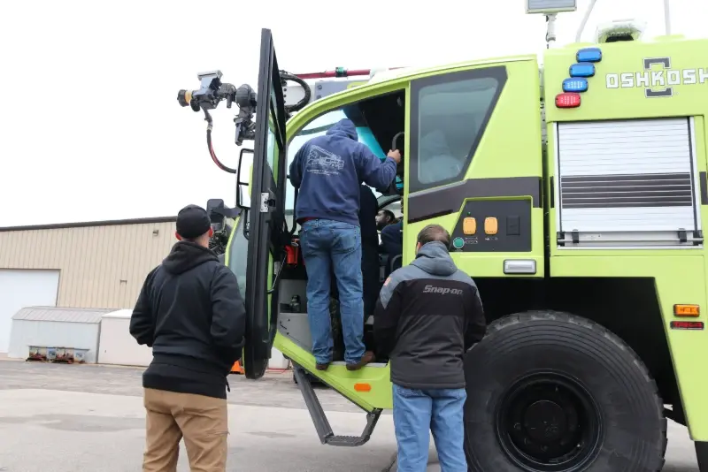 Technicians receive hands-on ARFF vehicle maintenance training with an Oshkosh fire truck