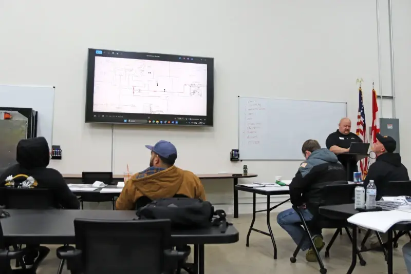 Technicians attend an ARFF technical training class focused on vehicle maintenance schematics