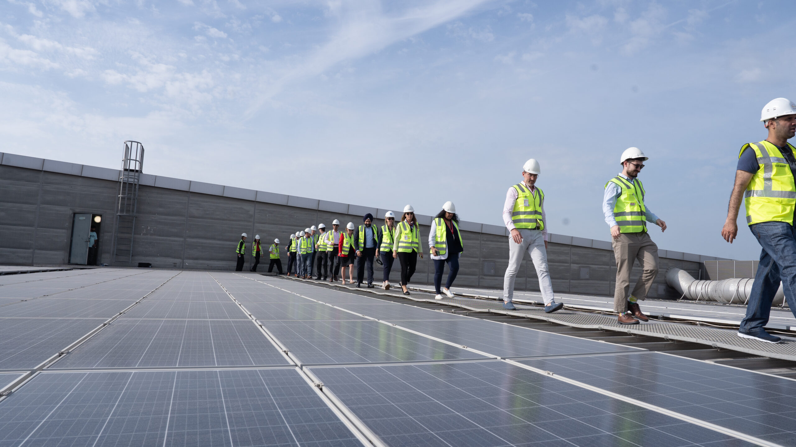 Workers walking across solar panels